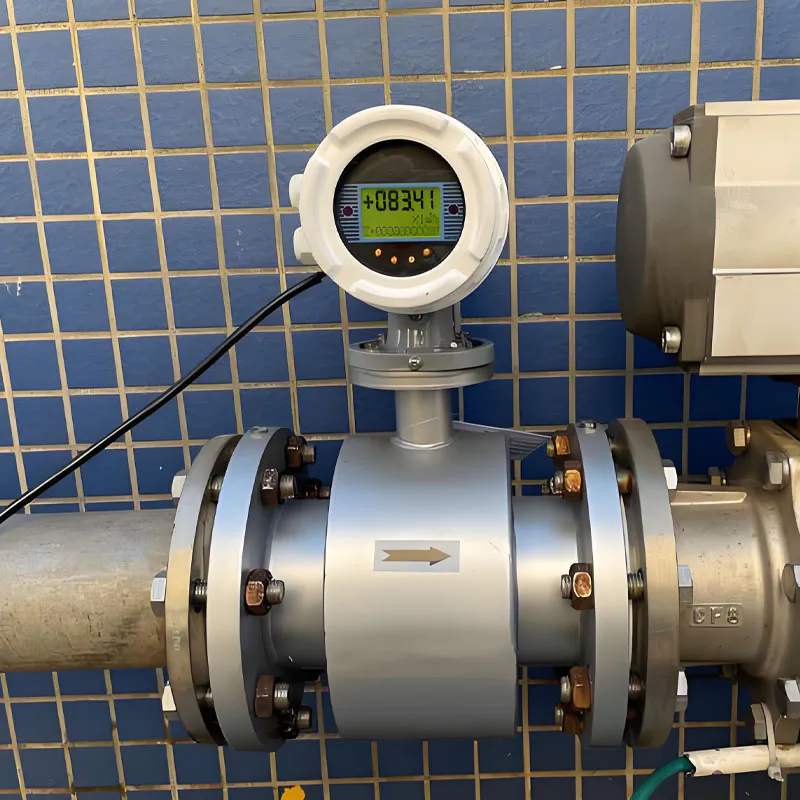 Electromagnetic flow meter installed on a pipeline with flanged connections and a digital transmitter for online measurement of conductive liquid flow.