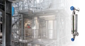 Bi-color quartz tube level gauge installed on an industrial pressure vessel for visual liquid level indication under high-temperature and high-pressure conditions.