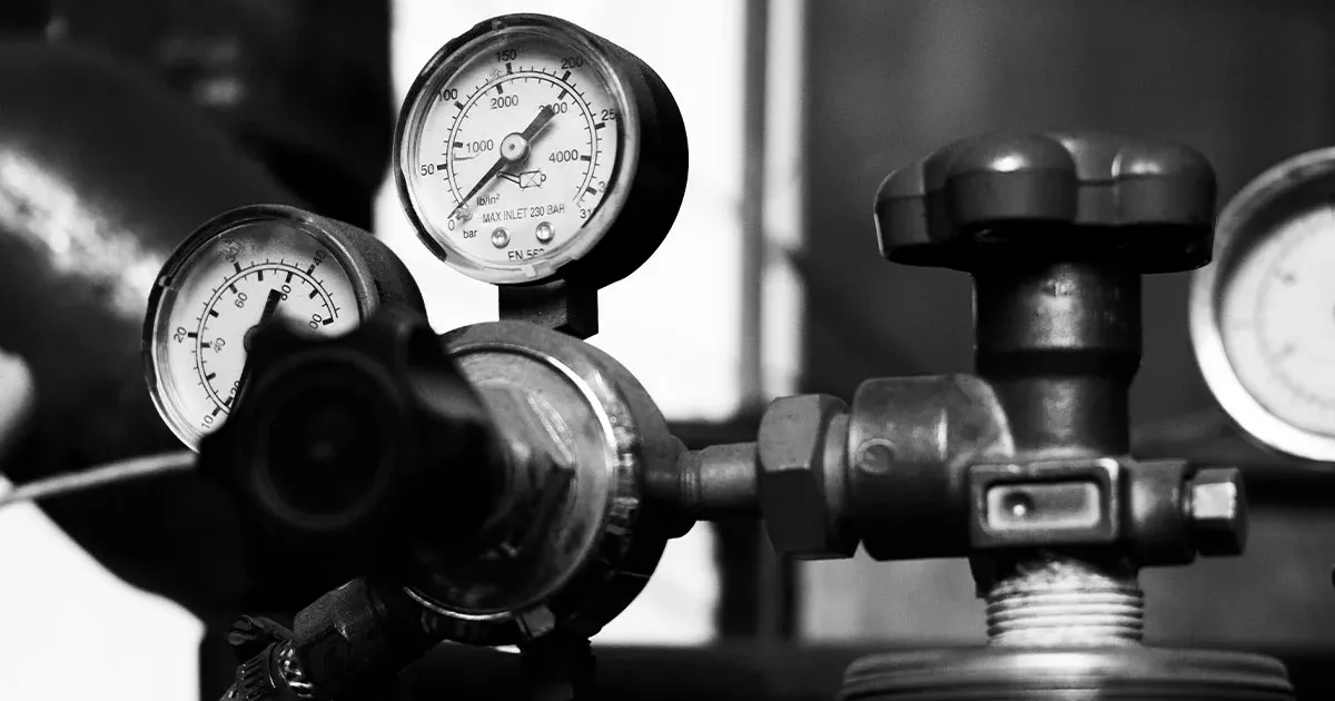This black-and-white image shows a close-up of a pressure gauge and valve, suitable for troubleshooting level transmitter issues and common problem-solving scenarios.