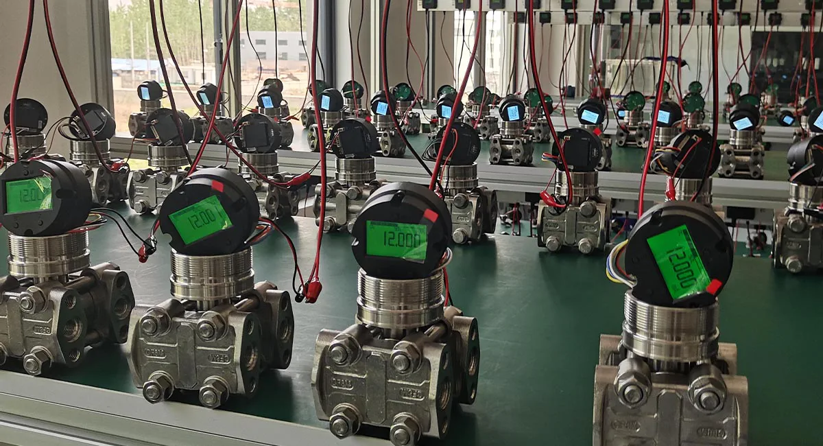 This image shows a pressure transmitter production line, where multiple devices are tested and assembled on the assembly table, displaying digital readings. These transmitters are used in industrial pressure measurement applications.