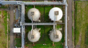 This image shows an overhead view of a water and wastewater treatment plant, featuring multiple storage tanks and piping systems, suitable for level measurement and control applications.