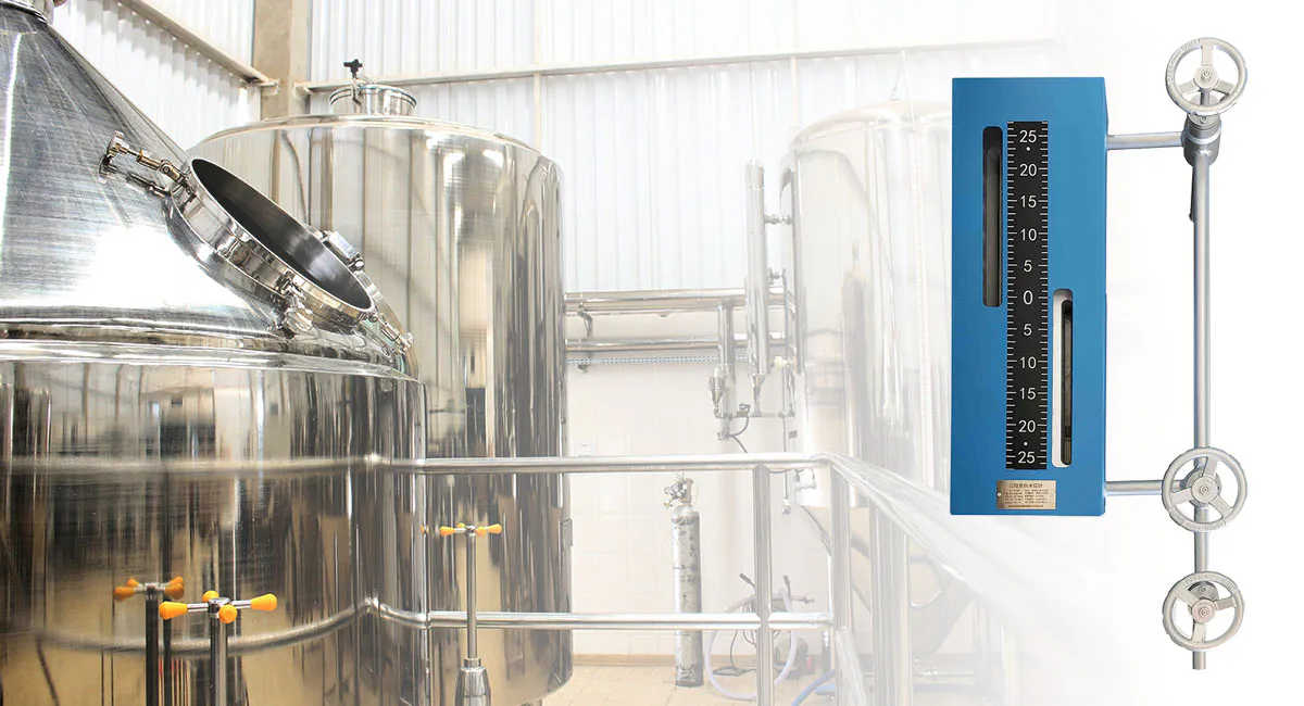 Bi-color level gauge mounted on a stainless steel process tank for real-time liquid level indication in a pressurized vessel.