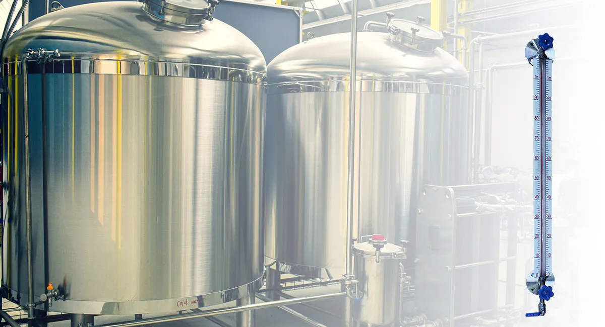 Glass type level gauge mounted on stainless steel industrial tanks for real-time liquid level monitoring.