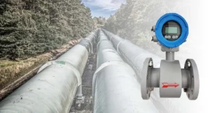 This image shows a magnetic flowmeter, with a long pipeline system in the background, suitable for liquid flow monitoring and control, particularly in industrial environments.