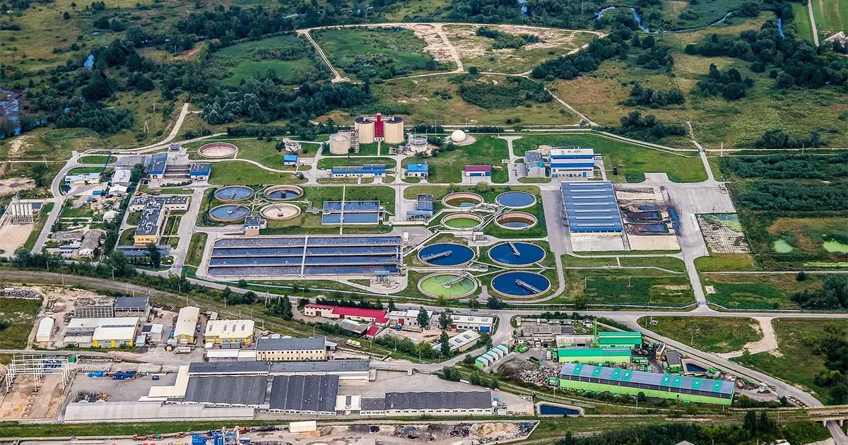 Wastewater treatment plant with sludge concentration monitoring systems