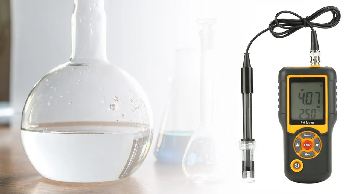 Portable pH meter with a black probe and liquid in the background.