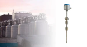 Water level float switch installed in an industrial tank setting with pipes and storage tanks