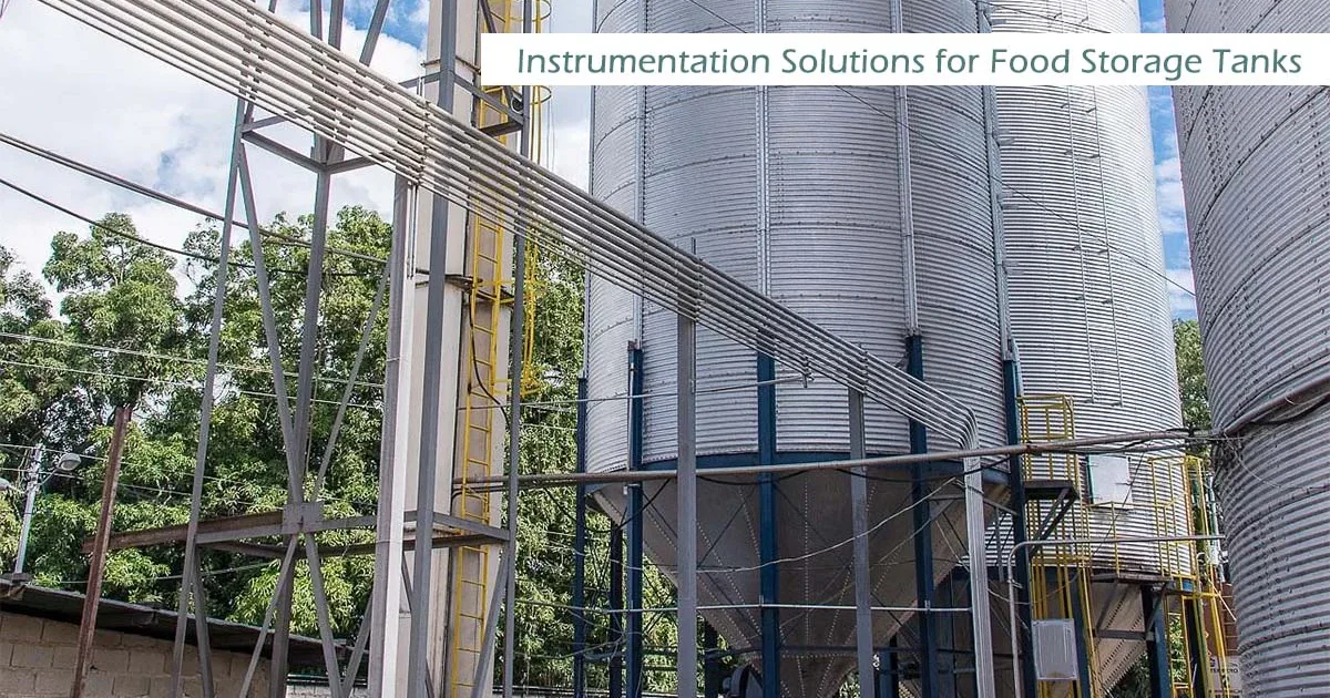 Grandes tanques y silos de almacenamiento industrial en una moderna planta de procesamiento de alimentos, mostrando soluciones profesionales de instrumentación para el control de nivel en la industria alimentaria.