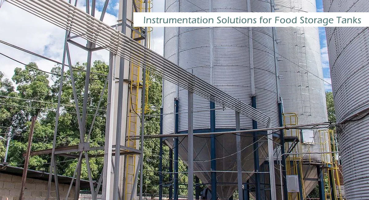 Grandes tanques y silos de almacenamiento industrial en una moderna planta de procesamiento de alimentos, mostrando soluciones profesionales de instrumentación para el control de nivel en la industria alimentaria.