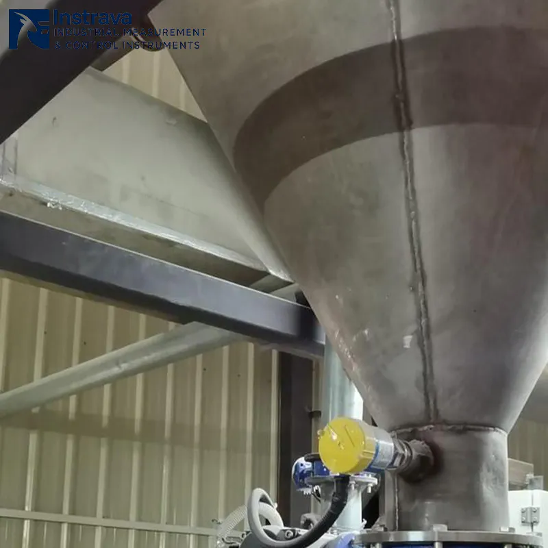 Real-world installation of an RF admittance level switch on an industrial conical hopper, showcasing high-reliability point level monitoring for bulk solids.