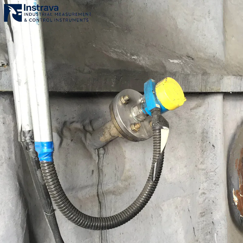 Working scene of a side-mounted flanged rotary paddle level switch installed on an industrial silo wall for high-level monitoring.