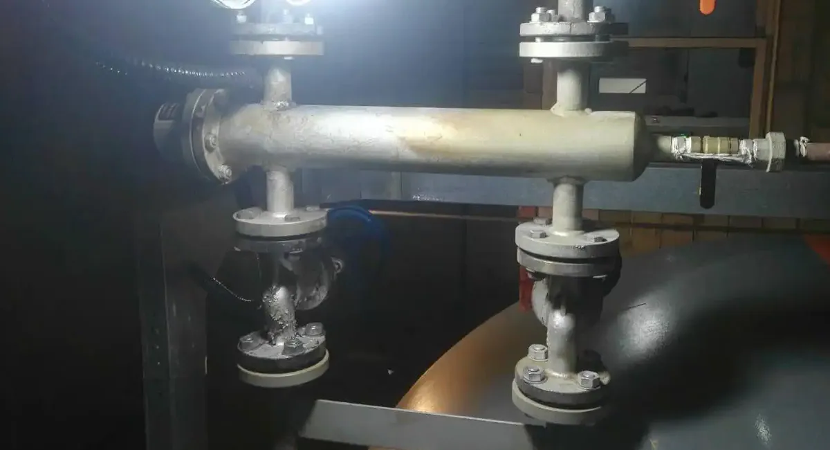 Electrode-type boiler level sensor installed on steam boiler piping system for water level monitoring and control