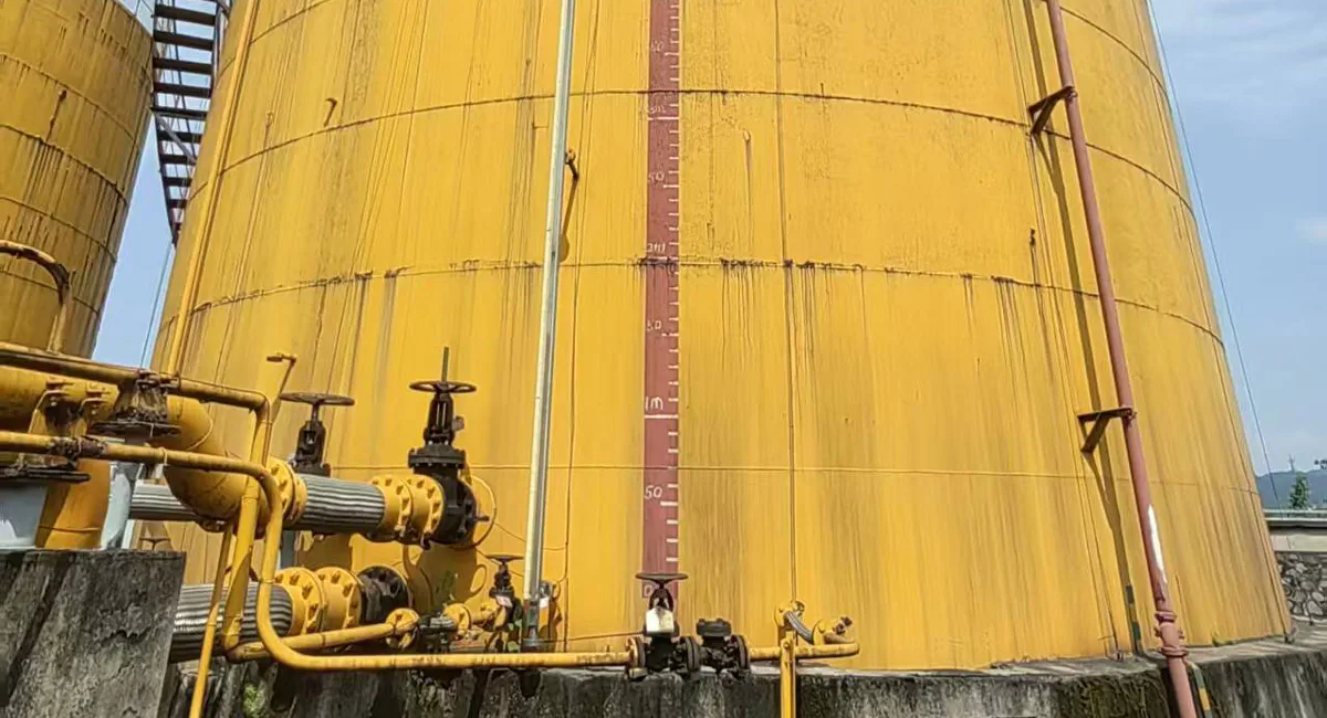 Magnetic level gauge installed on large industrial storage tank for continuous liquid level indication and monitoring