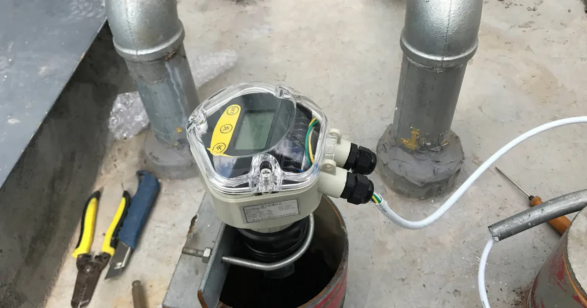 Ultrasonic level transmitter installed on a tank for continuous liquid level monitoring in industrial applications