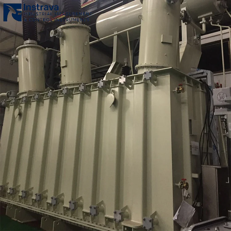 Side view of large oil-immersed power transformer, showing corrugated tank, high voltage bushings and valve connections, industrial substation main transformer photo