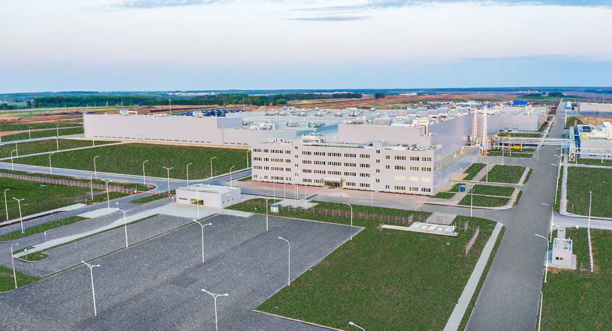 An aerial view of a large industrial equipment manufacturing plant or energy facility, surrounded by roads and infrastructure.